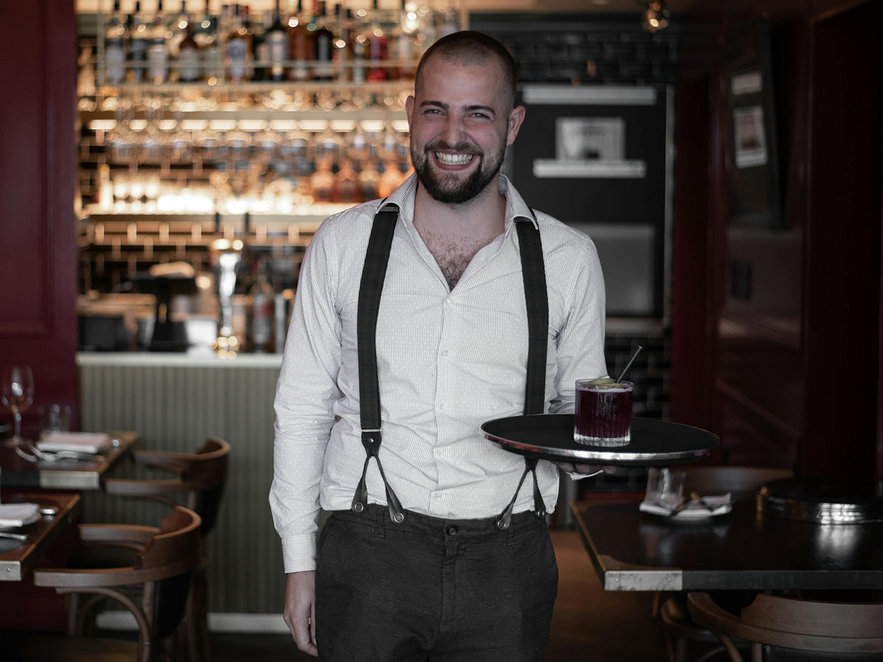 Servicemitarbeiter mit Tablett und Getränk im Restaurant